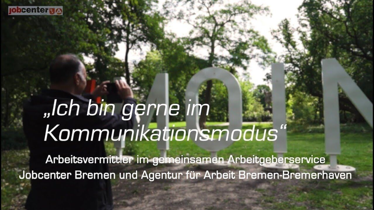 Ein Mann macht ein Foto eines Moin Schildes, im Vordergrund steht: Ich bin gerne im Kommunikationsmodus - Arbeitsvermittler in gemeinsamen Arbeitgeberservice Jobcenter Bremen und Agentur für Arbeit Bremen-Bremerhaven